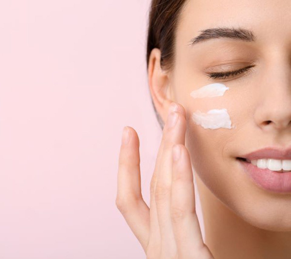 Woman applying SPF product to her cheek